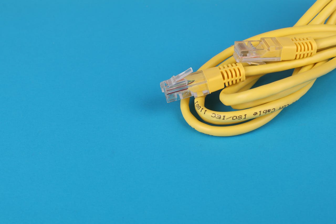 Žlutý ethernetový kabel omotaný na modrém pozadí