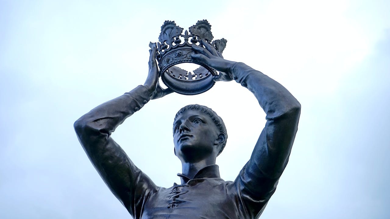 socha postavy držící korunu