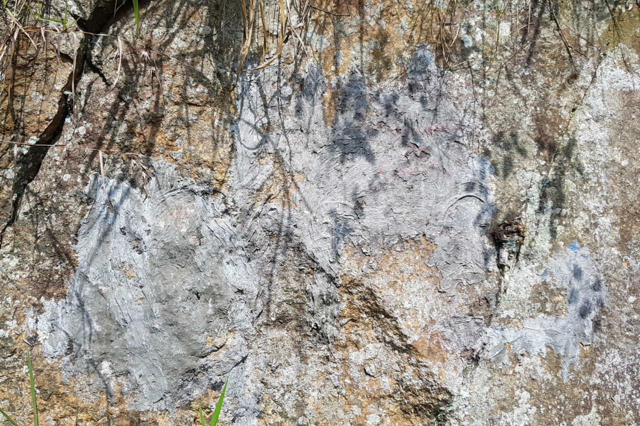 Фото скелі з цементом, що вкриває маркер